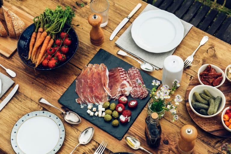 Platter of ham and salami with vegetables, on a wooden table. The Best Restaurants in Las Palmas. Experience the best food in Las Palmas de Gran Canaria. Article by https://www.kissmybackpack.com