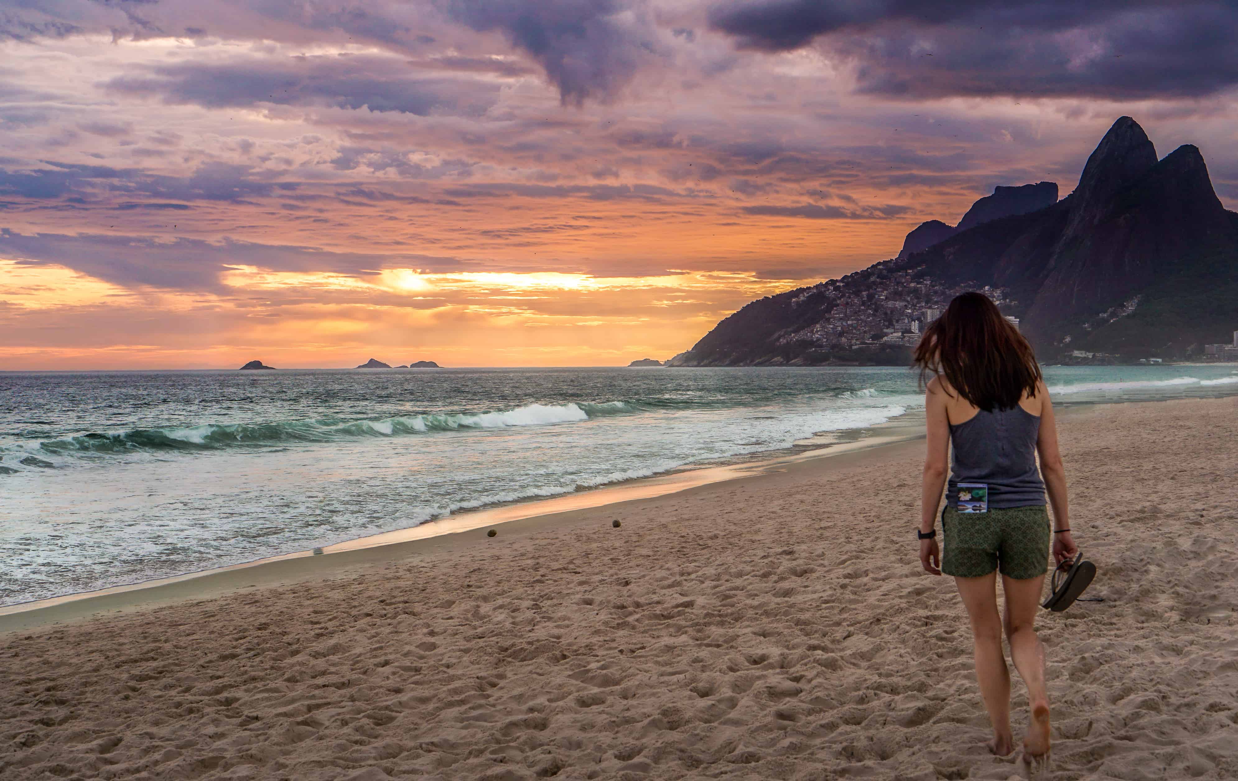 A woman walking on the beach towards the beautiful sunset in Rio de Janeiro